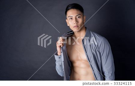 a young man is holding his shirt and showing his body 33324115