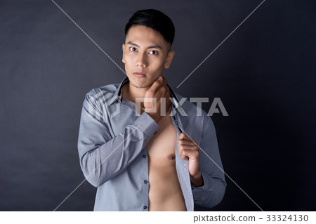 A portrait of strong man standing and touching his neck A portrait of strong man standing and touching his neck 33324130
