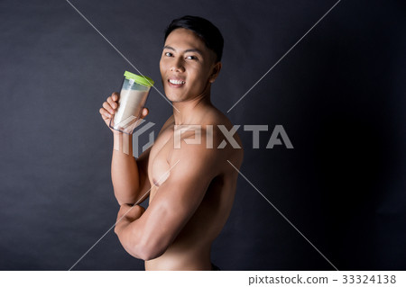 A sexy man is smiling and holding a bottle of drink A sexy man is smiling and holding a bottle of drink 33324138
