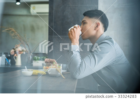 a photo of a man drinking coffee and having breakfast 33324283