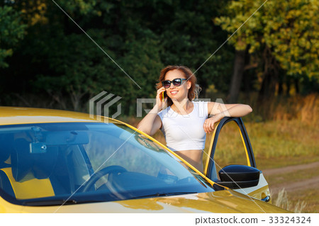 Girl is talking on phone by car Girl is talking on phone by car 33324324