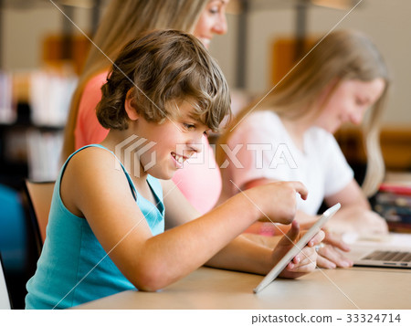 Boy in library with computer 33324714