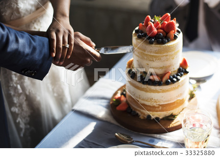 Couple Hands Cutting Wedding Cake Couple Hands Cutting Wedding Cake 33325880