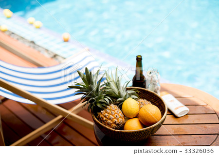 Closeup of tropical fruits in wooden basket by the poolside Closeup of tropical fruits in wooden basket by the poolside 33326036