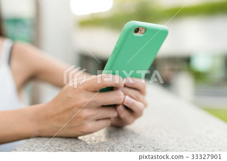 Woman using mobile phone in the street Woman using mobile phone in the street 33327901