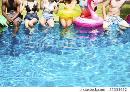 Group of diverse friends enjoying summer time by the pool with inflatable tubes Group of diverse friends enjoying summer time by the pool with inflatable tubes 33331652