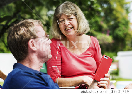 Caucasian couple listening to music together Caucasian couple listening to music together 33331719