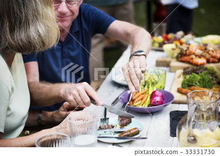 Man sharing food to woman at backyard barbecue party 33331730