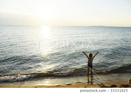 Silhouette rear view of young caucasian girl with arms raised at the beach alone Silhouette rear view of young caucasian girl with arms raised at the beach alone 33331825