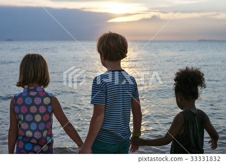 Rear view of diverse kids standing at the beach together 33331832