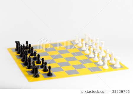 Black and white chess pieces aligned on a colorful chess board Black and white chess pieces aligned on a colorful chess board 33336705