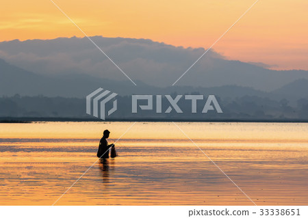 Silhouette of  fisherman setting fishing net 33338651