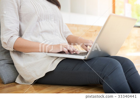 Young woman sitting on floor with laptop in library, education a Young woman sitting on floor with laptop in library, education a 33340441