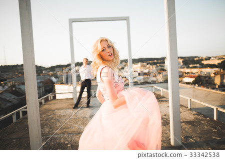 Fashion lovely beautiful couple posing on roof Fashion lovely beautiful couple posing on roof 33342538