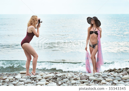 Two young girls in bathing suits are photographed Two young girls in bathing suits are photographed 33343345