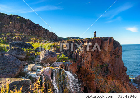 Girl in a dress on the edge of a cliff 33348946