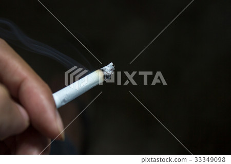 Human hand holding cigarette with smoke Human hand holding cigarette with smoke 33349098