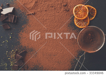 Cocoa powder in a sieve over black slate 33349846