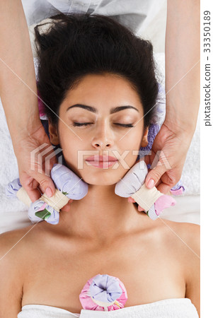 Woman has herbal ball massage in ayurveda spa Woman has herbal ball massage in ayurveda spa 33350189