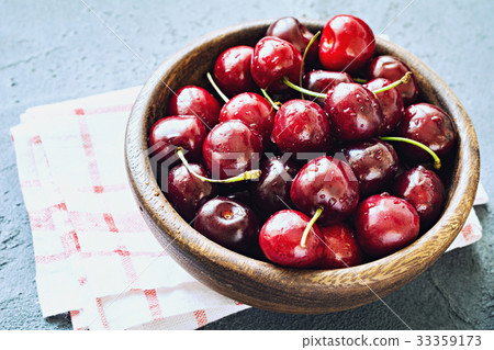 Bowl of fresh red cherries on blue background Bowl of fresh red cherries on blue background 33359173