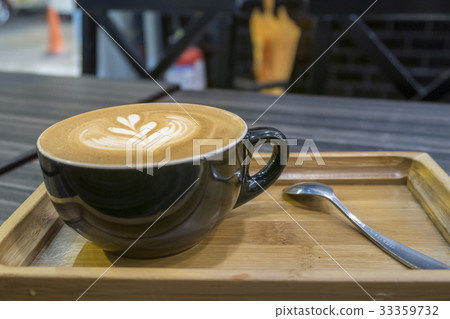 Hot art Latte Coffee in a cup on wooden tray Hot art Latte Coffee in a cup on wooden tray 33359732