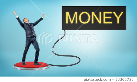 A victorious businessman stands on a large red A victorious businessman stands on a large red 33363783