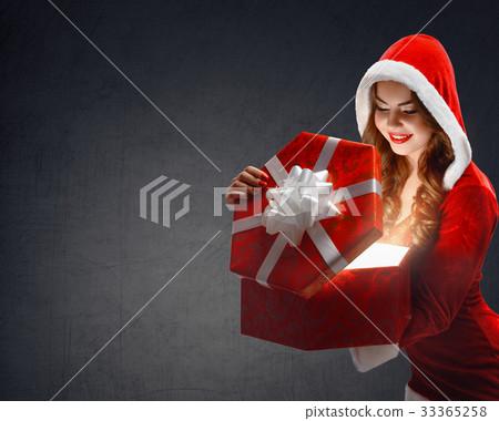 Snow Maiden in red suit smiling holding a gift Snow Maiden in red suit smiling holding a gift 33365258