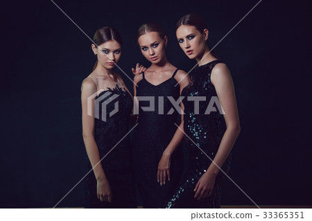 Beautiful women in black cocktail dresses on a Beautiful women in black cocktail dresses on a 33365351