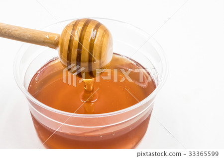 Honey with wood stick on white background. Honey with wood stick on white background. 33365599