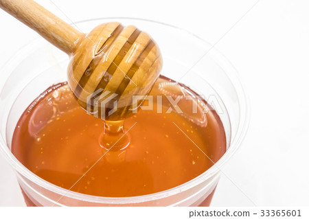 Honey with wood stick on white background. Honey with wood stick on white background. 33365601