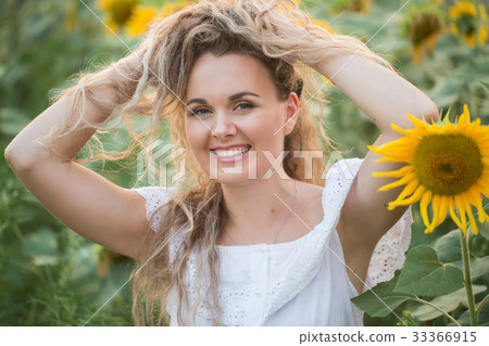 Young woman in a field of sunflowers. sunset light Young woman in a field of sunflowers. sunset light 33366915