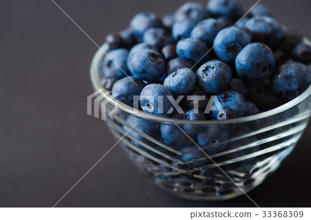 Fresh blueberries in white bowl on wood table Fresh blueberries in white bowl on wood table 33368309