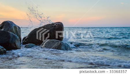 Wave splash in the sea against stone 33368357