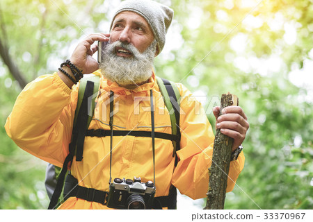 Thoughtful old man communicating on smartphone in 33370967