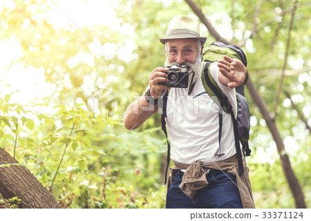 Positive retired male photographer entertaining in 33371124