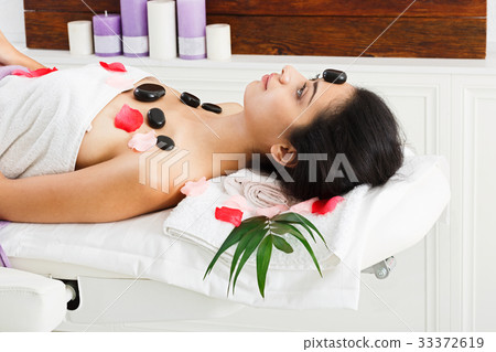 Beautiful girl at stone massage spa in wellness 33372619