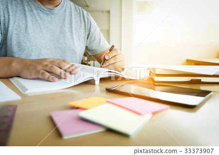 Close up of studying student hands writing in book 33373907