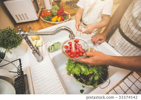 Father with son washes vegetables before eating Father with son washes vegetables before eating 33374542
