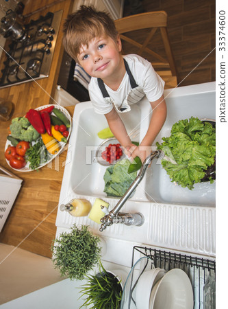 Little boy washes vegetables before eating 33374600