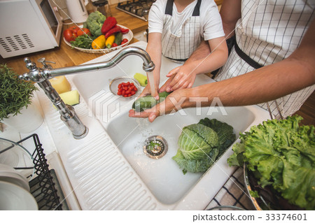 Father with son washes vegetables before eating Father with son washes vegetables before eating 33374601