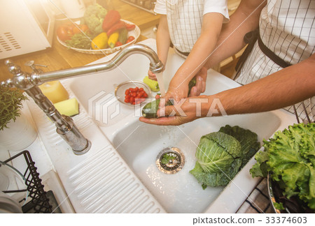 Father with son washes vegetables before eating 33374603
