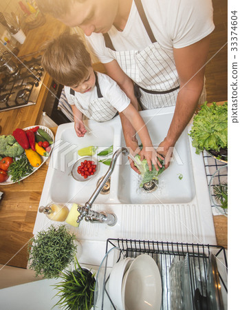 Father with son washes vegetables before eating 33374604