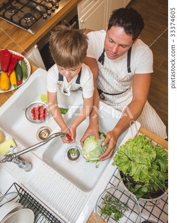 Father with son washes vegetables before eating Father with son washes vegetables before eating 33374605