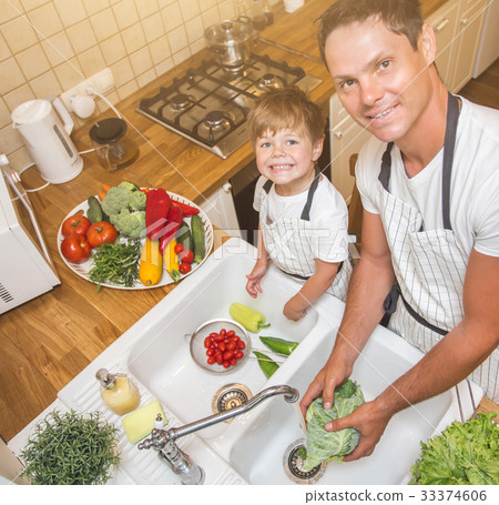 Father with son washes vegetables before eating Father with son washes vegetables before eating 33374606