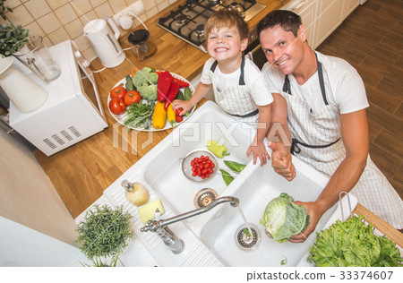 Father with son washes vegetables before eating Father with son washes vegetables before eating 33374607