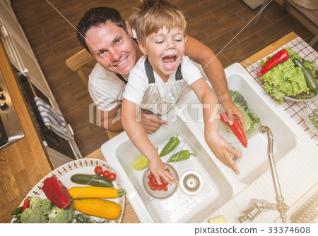 Father with son washes vegetables before eating Father with son washes vegetables before eating 33374608