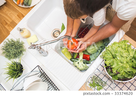 Father with son washes vegetables before eating 33374620