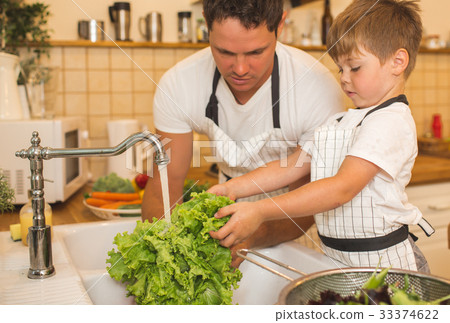 Father with son washes vegetables before eating 33374622