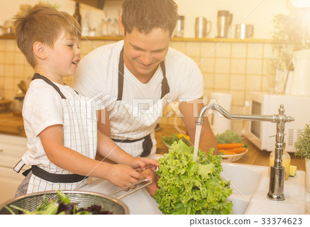 Father with son washes vegetables before eating 33374623