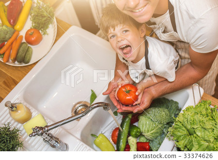 Father with son washes vegetables before eating 33374626